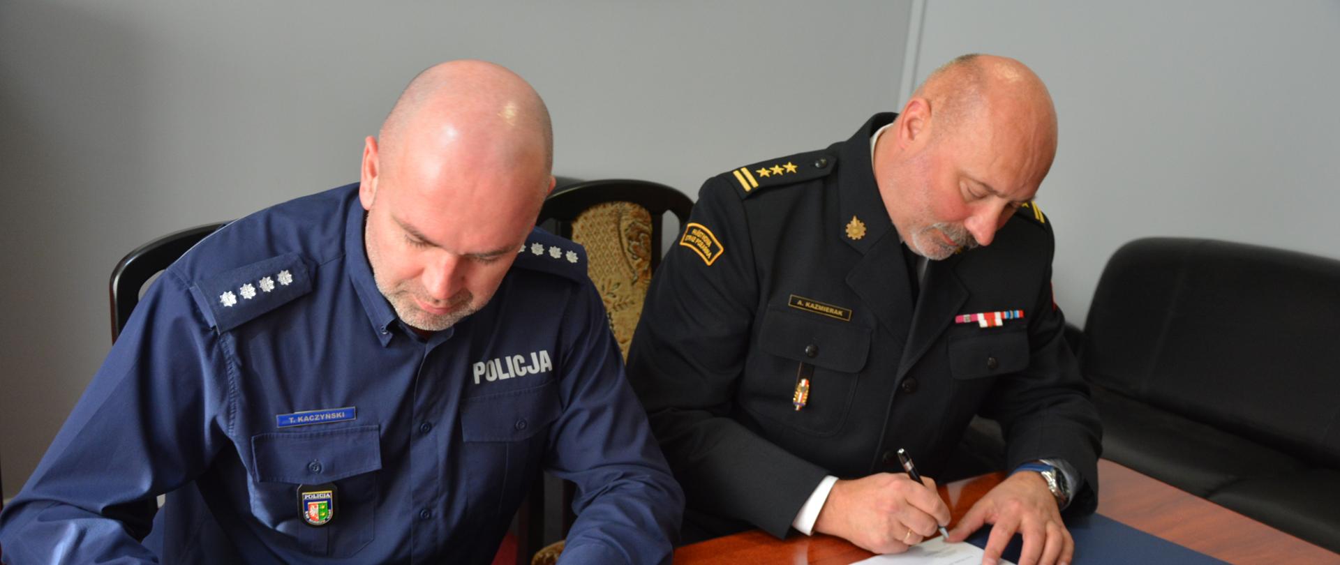 Zdjęcie przedstawia od lewej strony Komendanta Powiatowego Policji w Krośnie Odrzańskim nadkomisarza Tomasza Kaczyńskiego oraz Komendanta Powiatowego Państwowej Straży Pożarnej w Krośnie Odrzańskim st. bryg. Andrzeja Kaźmierak podpisujących list intencyjny dotyczący współpracy w zakresie ustalania przyczyn powstawania pożarów na terenie powiatu krośnieńskiego.