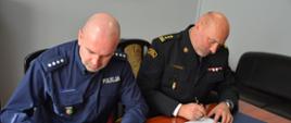 Zdjęcie przedstawia od lewej strony Komendanta Powiatowego Policji w Krośnie Odrzańskim nadkomisarza Tomasza Kaczyńskiego oraz Komendanta Powiatowego Państwowej Straży Pożarnej w Krośnie Odrzańskim st. bryg. Andrzeja Kaźmierak podpisujących list intencyjny dotyczący współpracy w zakresie ustalania przyczyn powstawania pożarów na terenie powiatu krośnieńskiego.