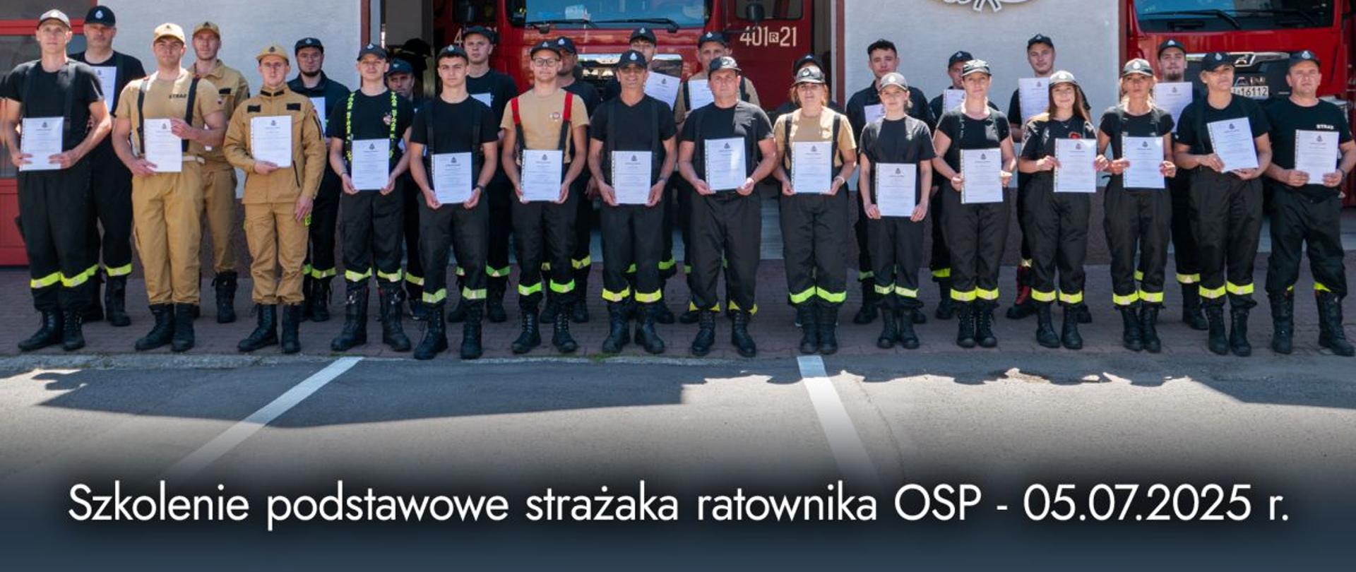 Zdjęcie przedstawia uczestników kursu podstawowego z dyplomami ukończenia przed garażami JRG Ustrzyki Dolne