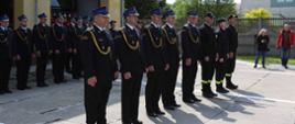 Strażacy awansowani na wyższe stanowiska służbowe, w tle pododdział funkcjonariuszy