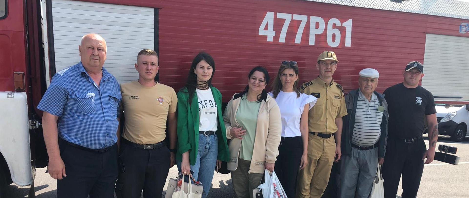 Strażacy oraz przedstawiciele gminy na tle pojazdu pożarniczego.