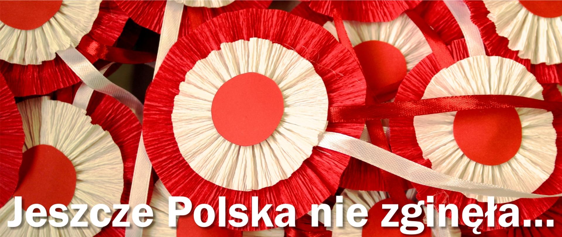 Grafika przedstawia białoczerwone kotyliony i prezentuje napis Jeszcze Polska nie zginęła...