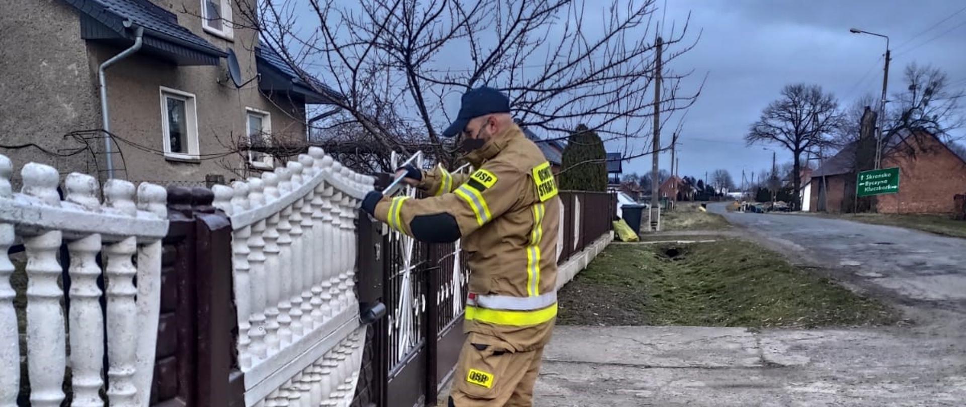 Strażak OSP Kujakowice Dolne podczas kolportażu ulotek 
