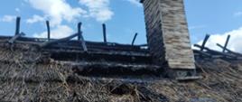 Widoczne miejsce zdarzenia dach kryty strzechą, fragment dachu zniszczony w wyniku pożaru.