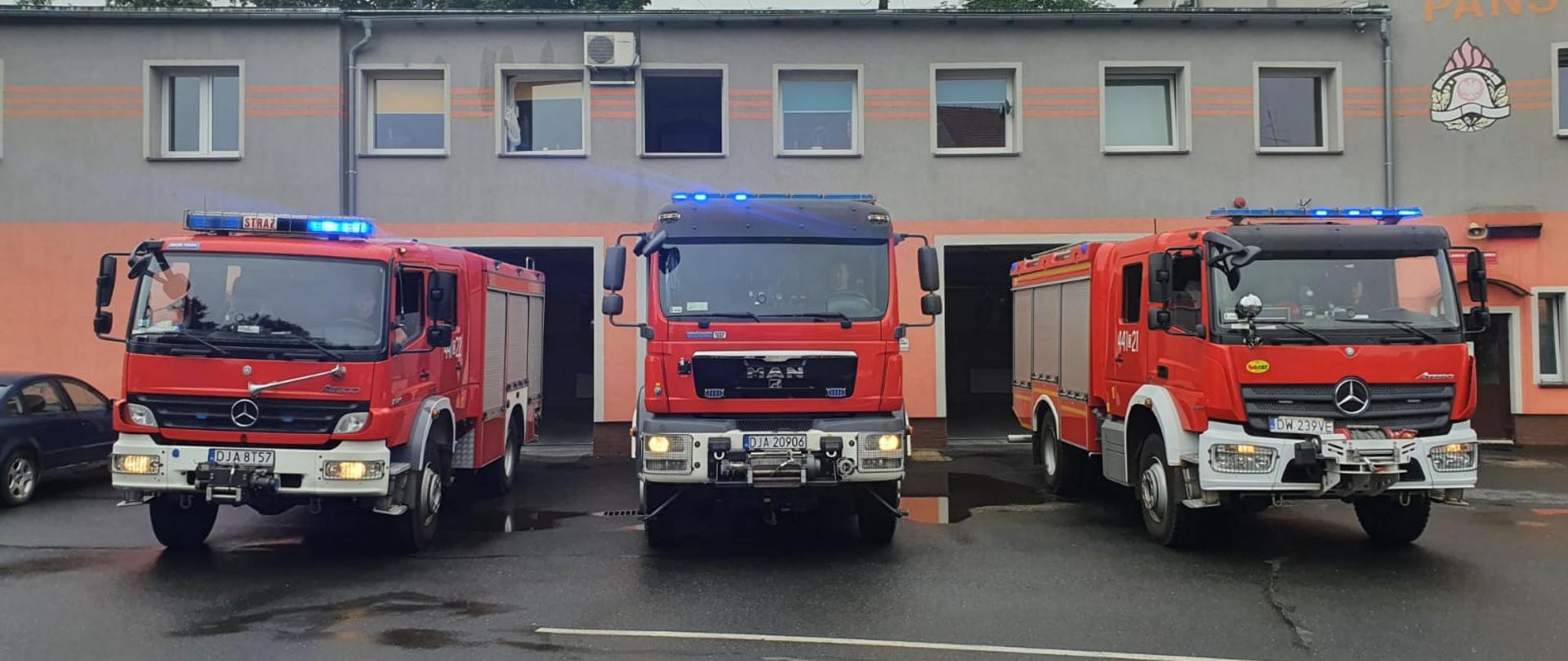 Obraz przedstawia samochodu pożarnicze z włączonymi sygnałami dźwiękowymi i świetlnymi podczas obchodów 77 rocznicy wybuchu Powstania Warszawskiego