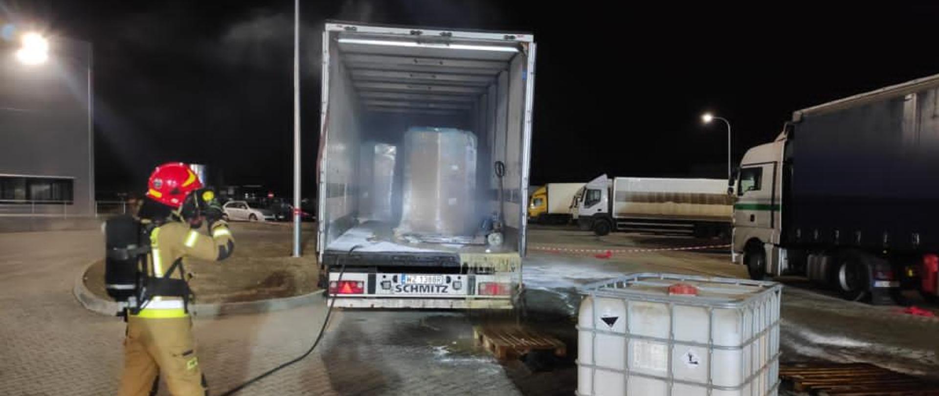 Zdjęcie otwartej naczepy ciężarówki i strażaka