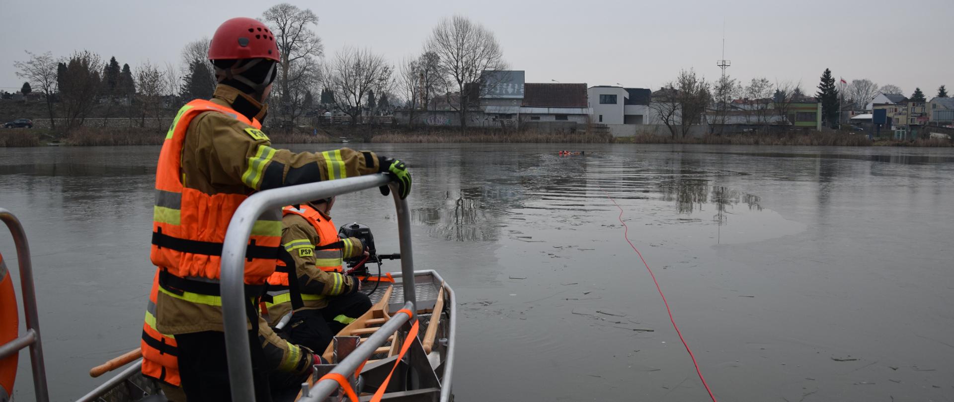 Funkcjonariusze w łodzi przy brzegu oczekują na rozpoczęcie ćwiczeń