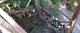 Widok z góry na wchodzących na wieżę widokową strażaków. 
