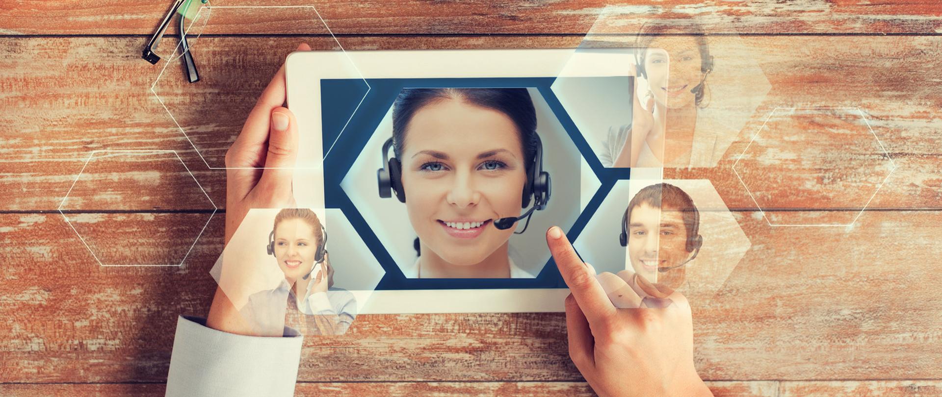 Twarz konsultantki na ekranie tabletu, dłonie trzymające tablet.