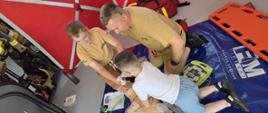 Uczestnicy spotkania ćwiczący udzielanie pierwszej pomocy w ramach Akademii Ochrony Ludności i Obrony Cywilnej pod okiem st. asp. Manerowskiego Radosława