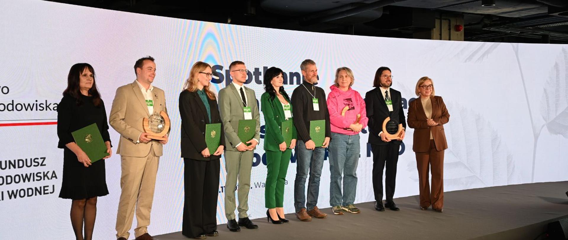 Na zdjęciu widać 9 osób - wśród nich są zwyciężczynie i zwycięzcy konkursu Klimatyczny Człowiek Roku 2025. Po prawej stronie stoi także minister Paulina Henning-Kloska. 