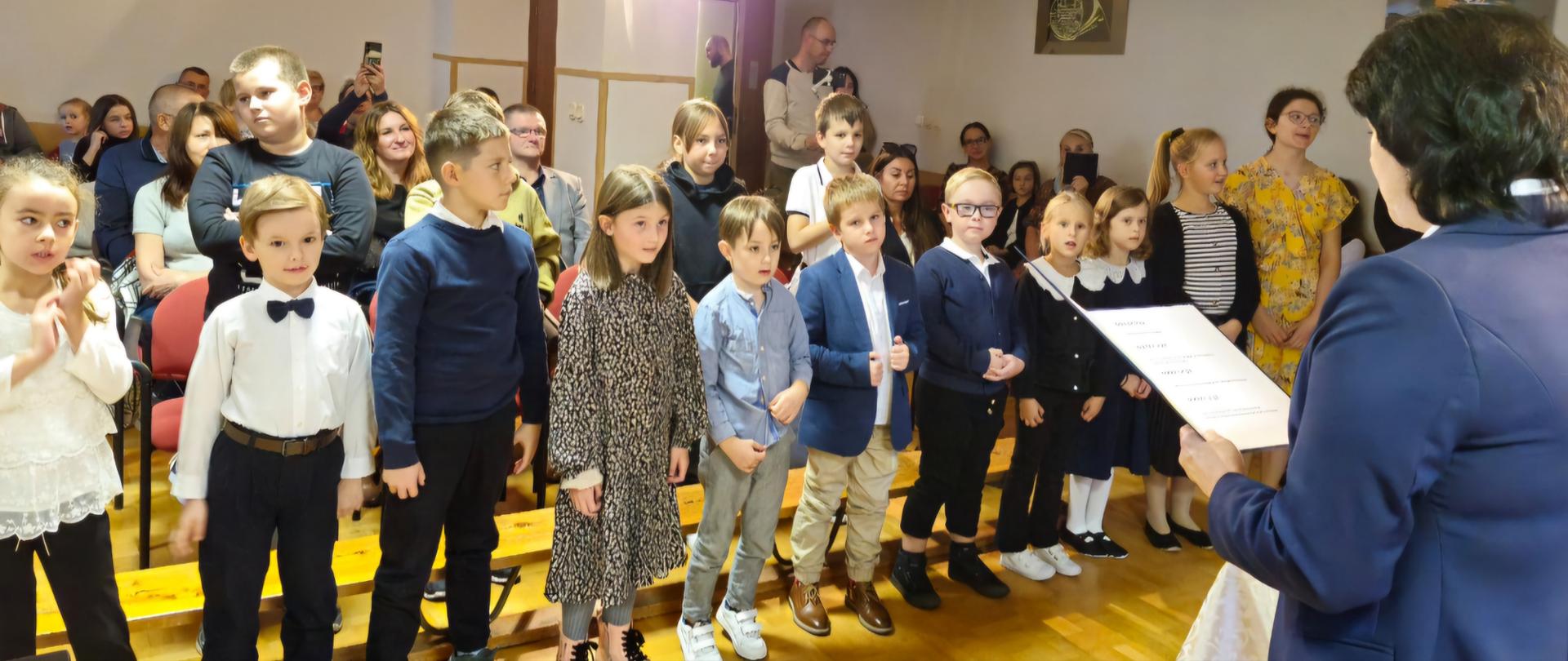 Zdjęcie z uroczystości pasowania na ucznia dzieci wraz z dyrektorem szkoły.