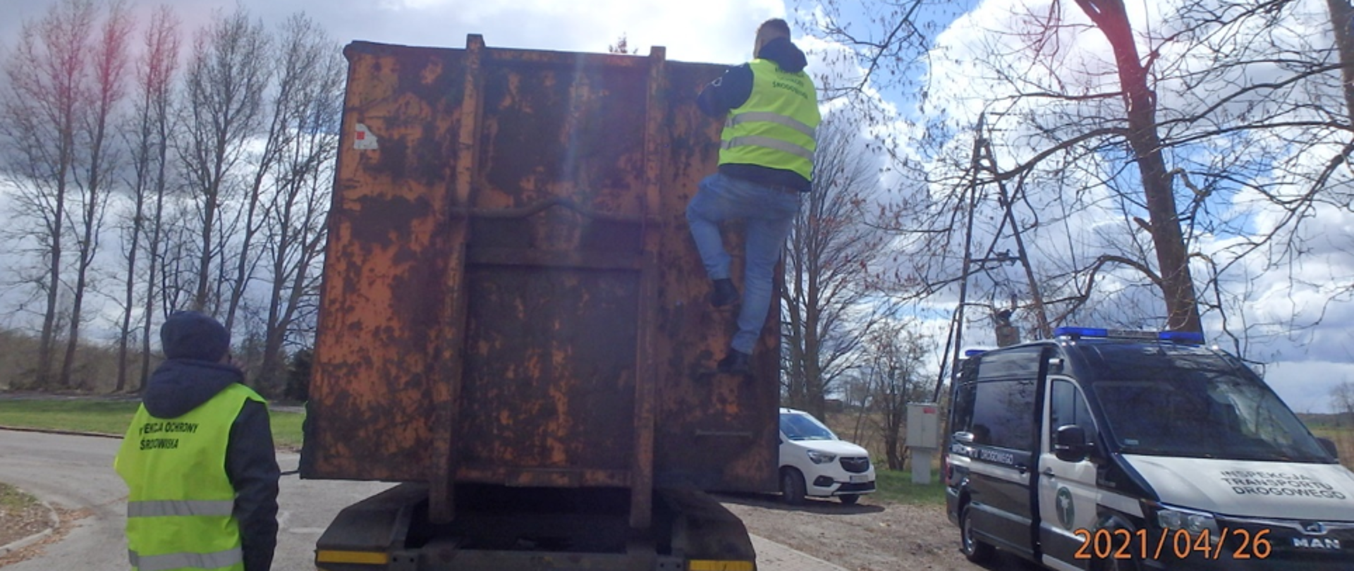 Inspektor wchodzący na naczepę ciężarówki.