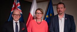 Karolina Cemka, Chargé d’Affaires Ambasadry RP w Canberze, i Mark Banasiak MLC, członek Izby Legislacyjnej Nowej Południowej Walii na tle flag państwowych.