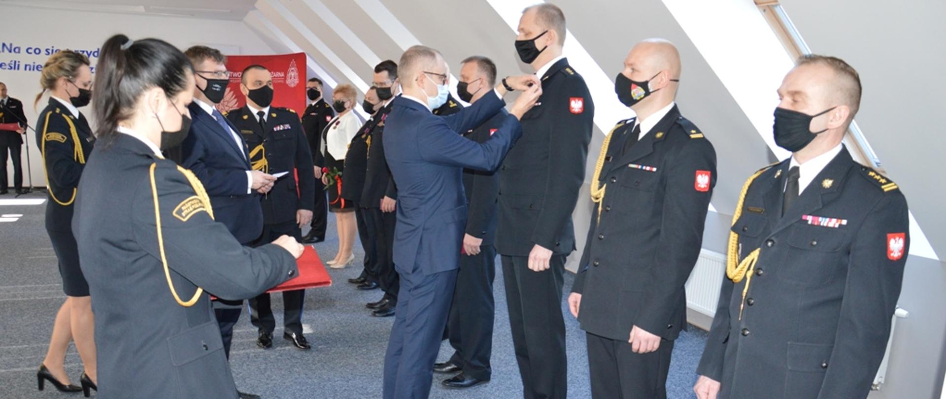 Wiceminister Ministerstwa Spraw Wewnętrznych i Administracji wręcza odznaczenia. 