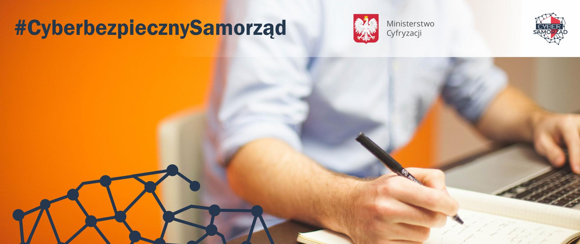 Mężczyzna przy biurku - bliskie ujęcie, od klatki piersiowej. Lewą rękę trzyma na klawiaturze laptopa, w prawej trzyma długopis i notuje coś w zeszycie w kratkę. Tło pomarańczowe. Napis: #CyberbezpiecznySamorząd. Logotypy programu i MC.