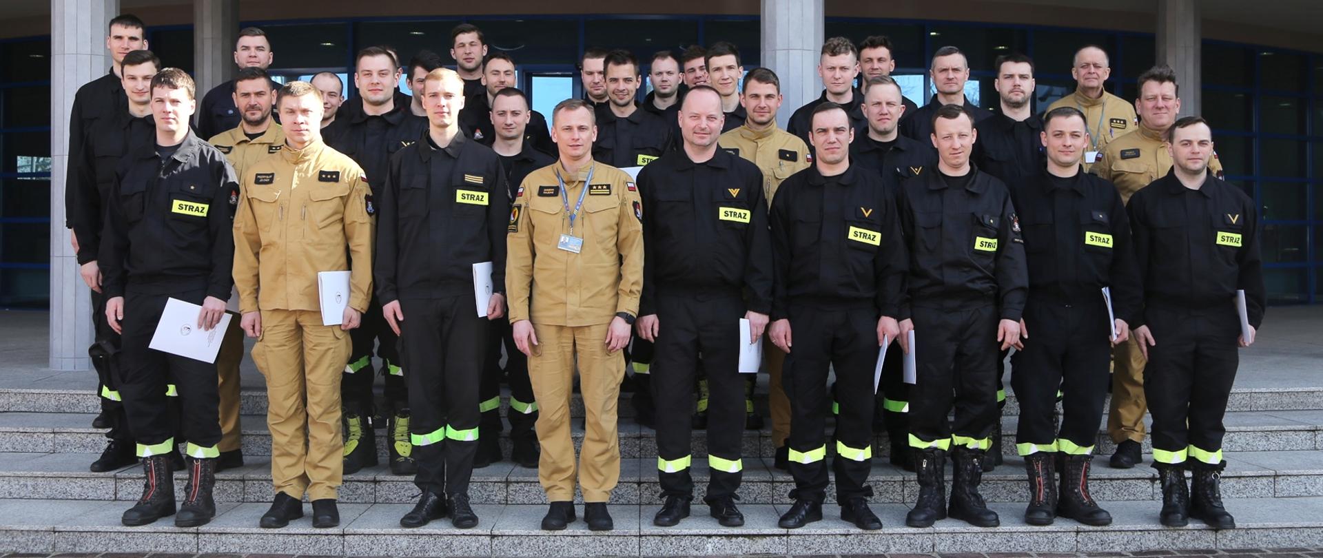 Grupowe zdjęcie uczestników szkolenia (28 funkcjonariuszy PSP) w towarzystwie Zastępcy Komendanta Centralnej Szkoły PSP oraz dwóch funkcjonariuszy CS PSP
