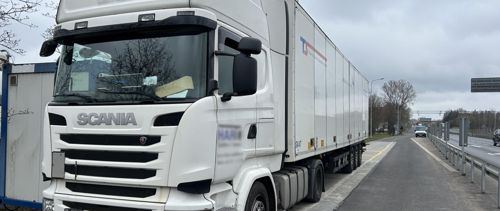 Na zdjęciu widoczny zaparkowany biały pojazd ciężarowy.