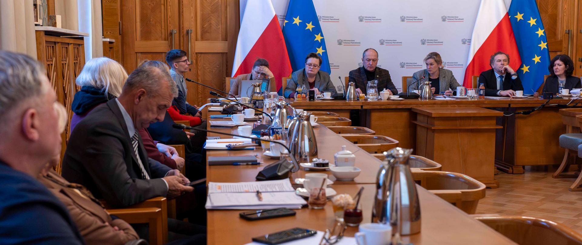 Zdjęcie przedstawia uczestników spotkania z oświatowymi związkami zawodowymi w Ministerstwie Edukacji Narodowej. Wszyscy siedzą przy stole.