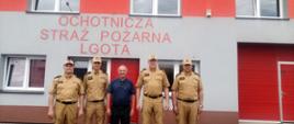 Zdjęcie od frontu. Przed głównym wejściem do budynku OSP Lgota stoją od lewej: Naczelnik Wydziału Logistyki KW PSP w Krakowie, Zastępca Małopolskiego Komendanta Wojewódzkiego, Prezes OSP w Lgocie, Zastępca Komendanta Głównego PSP oraz Komendant Powiatowy PSP w Wadowicach. 