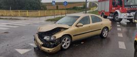 Uszkodzony pojazd na drodze obok dwa samochody strażackie