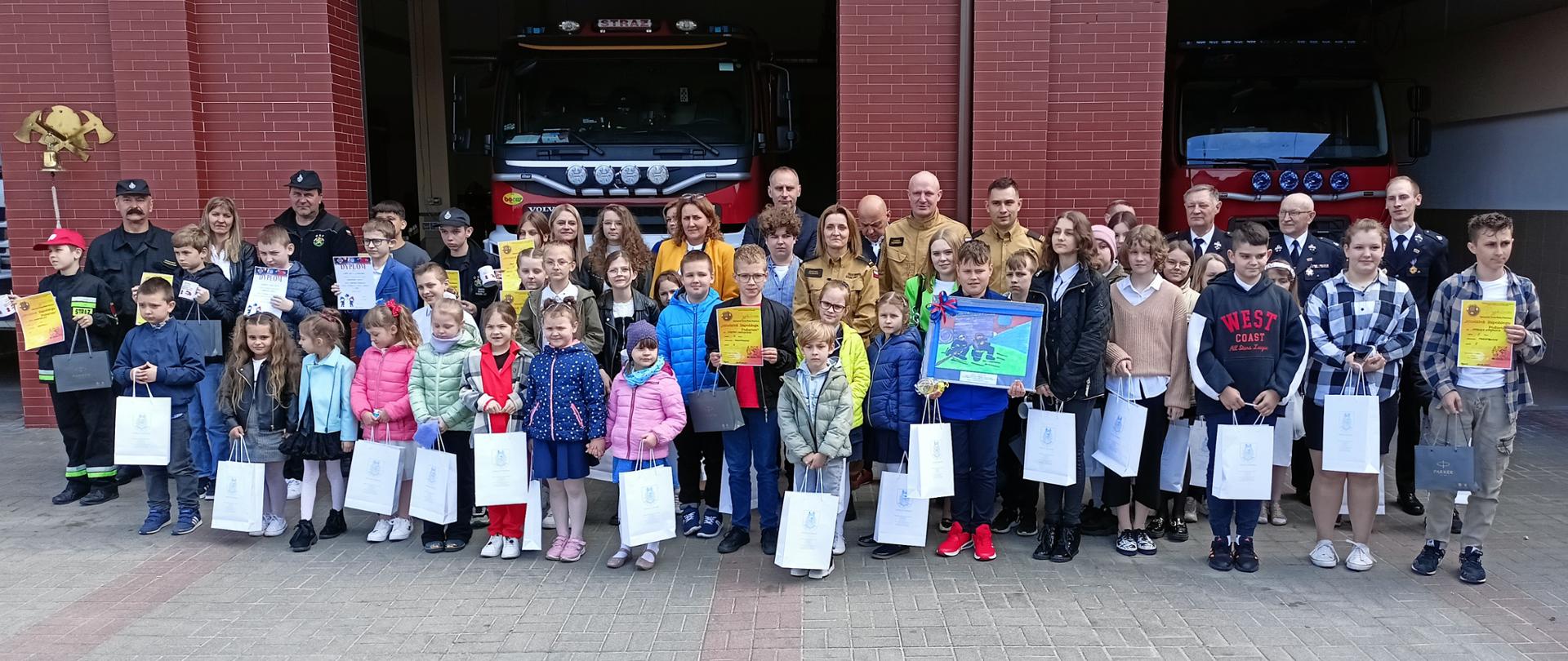 Zdjęcie zbiorowe uczestników powiatowych eliminacji do Ogólnopolskiego Turnieju Wiedzy Pożarniczej "Młodzież Zapobiega Pożarom" w Rypinie wraz z komisją i opiekunami.