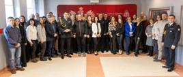 Wspólne zdjęcie uczestników uroczystego spotkania z okazji Dnia Służby Cywilnej. Zdjęcie wykonane w świetlicy Komendy Miejskiej PSP w Opolu.