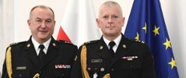Pomorski Komendant Wojewódzki PSP st. bryg. Jacek Niewęgłowski i Zastępca Komendanta Powiatowego Państwowej Straży Pożarnej w Człuchowie bryg. Dariusz Dwulit stoją na tle flagi państwowej i flagi unii europejskiej.