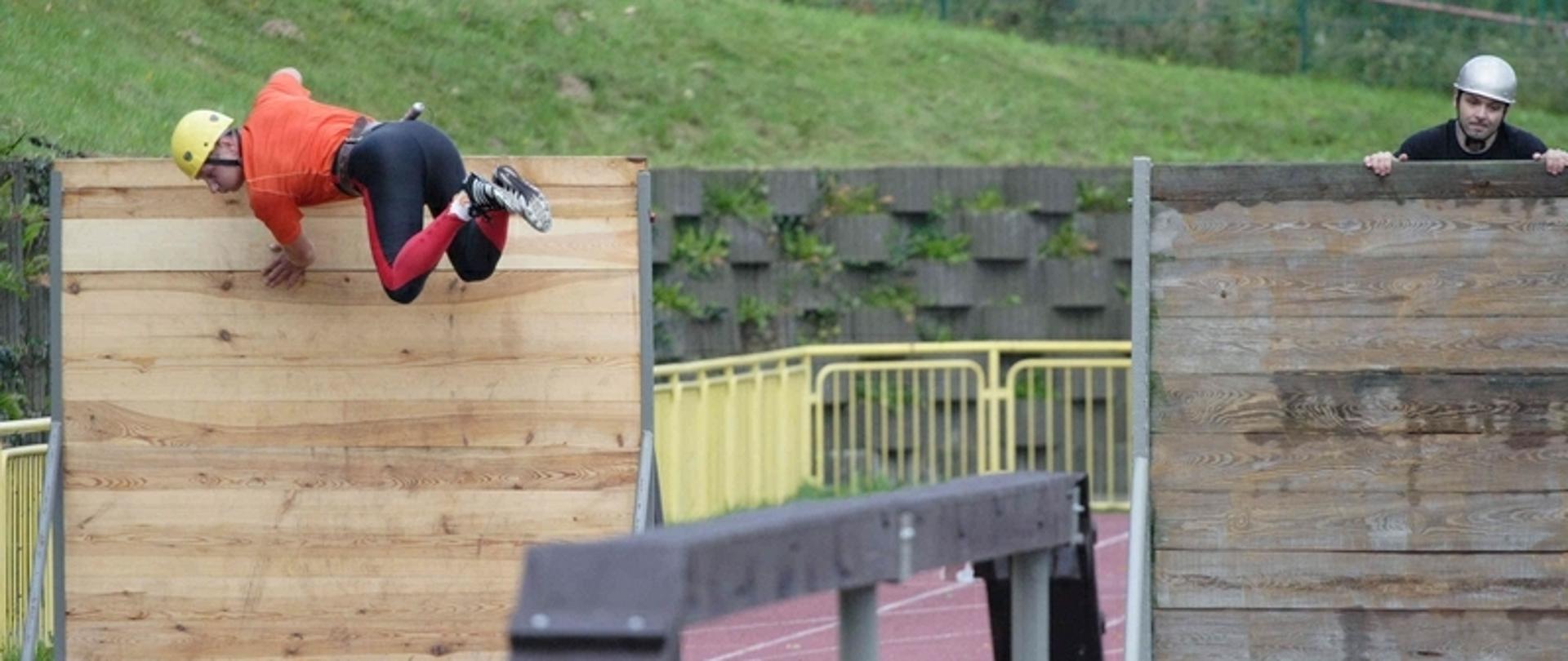 Zdjęcie przedstawia zawodnika pokonującego przeszkodę 