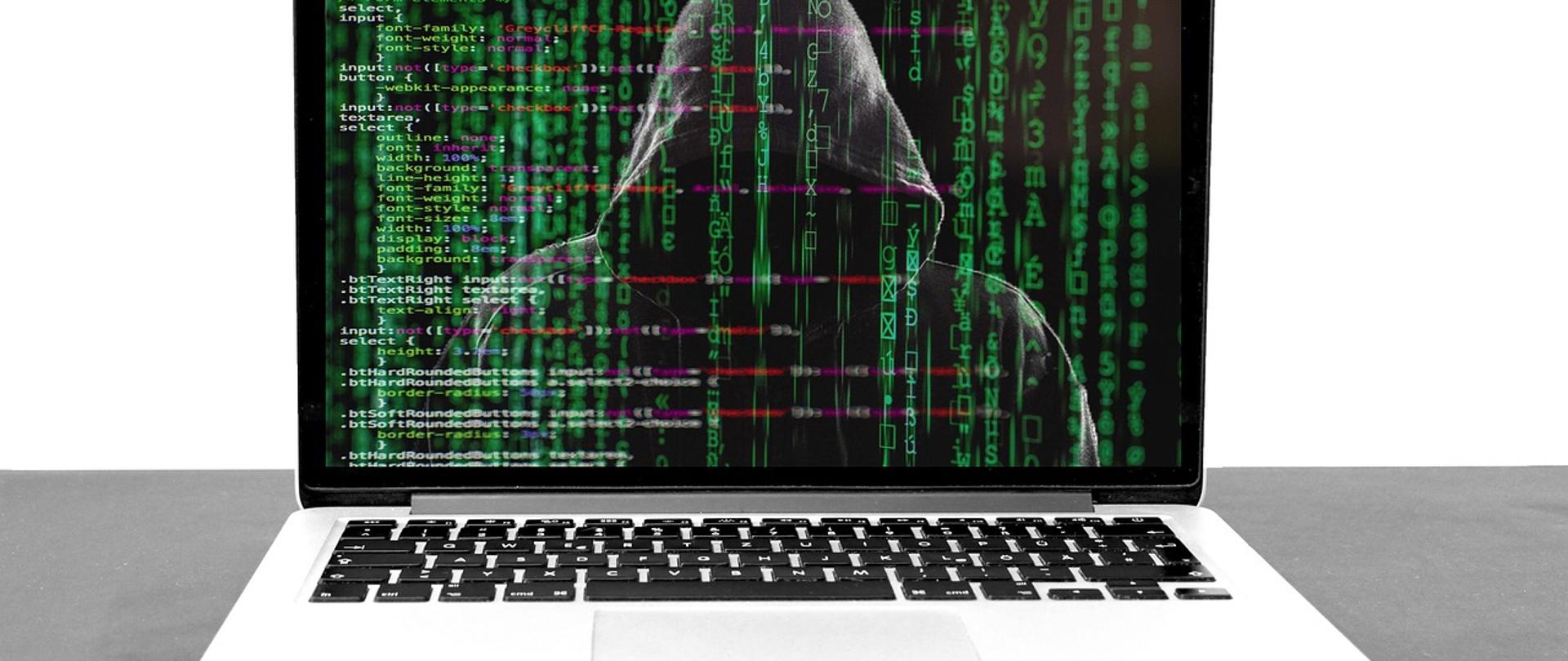 postać osoby w kapturze na ekranie laptopa