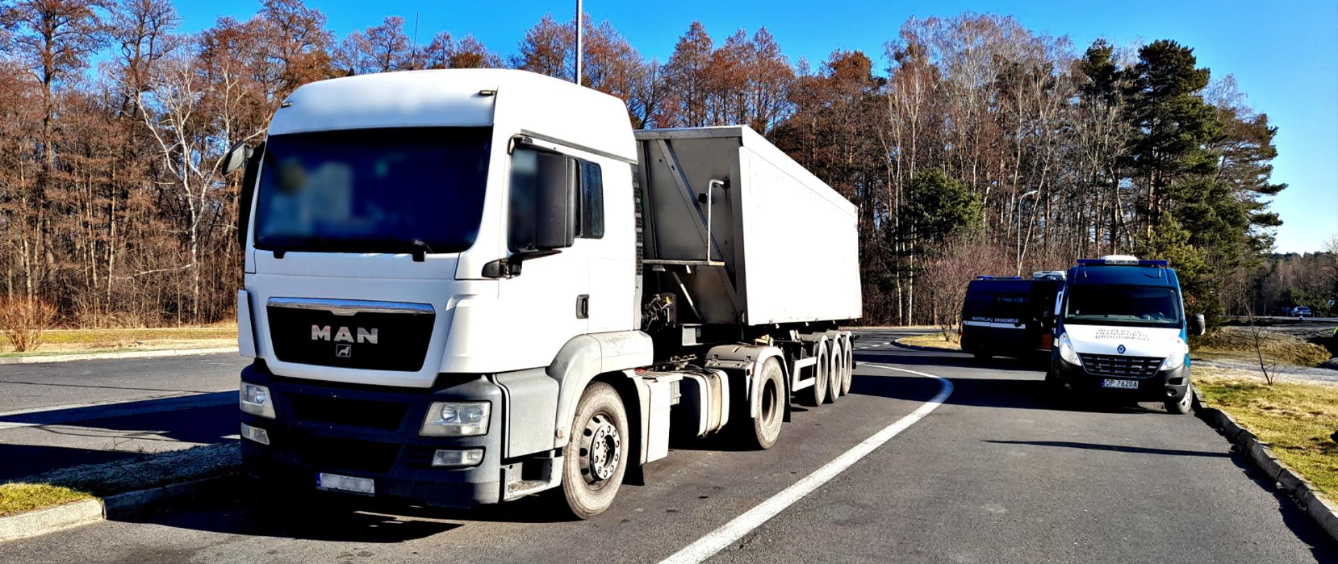 Jedna z ciężarówek zatrzymanych do kontroli stanu technicznego. Po lewej ciężarówka, po prawej dwa furgony Inspekcji Transportu Drogowego.