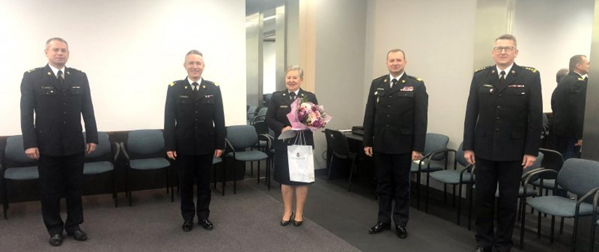 Pożegnanie ze służbą w PSP – na zdjęciu czterej komendanci PSP i st. bryg. Danuta Wojciechowska z kwiatami.