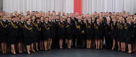 Zdjęcie grupowe prawie 200 funkcjonariuszy. wszyscy w mundurach galowych - w tle flaga biało-czerwona i godło narodowe.