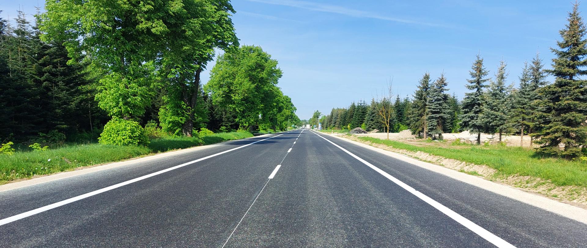 DK73 Szczeglin - Pacanów - wyremontowany odcinek drogi z nową nawierzchnią asfaltową. Wzdłuż jezdni białe linie oznakowania poziomego, po bokach ciągłe, po środku przerywana. Wzdłuż drogi zielone drzewa liściaste i iglaste. 