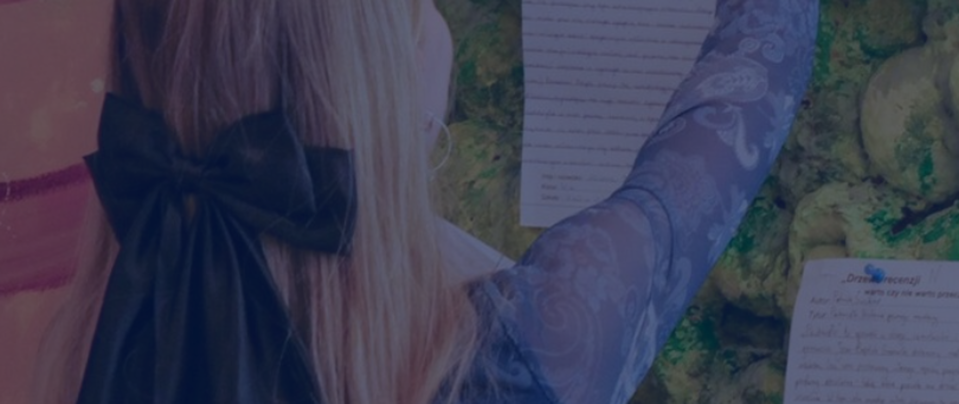 Grafika przedstawia fragment sceny z osobą stojącą tyłem, która przypina kartki z tekstem na tablicy. Na jednej z kartek można częściowo odczytać nagłówek „Drzewo recenzji”.