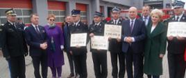 Zdjęcie przedstawia strażaków oraz zaproszonych gości podczas wręczenia promes na zakup pojazdów