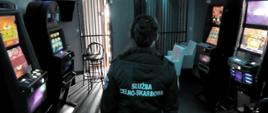 Funkcjonariuszka Służby Celno-Skarbowej na tle zatrzymanych automatów do gier hazardowych