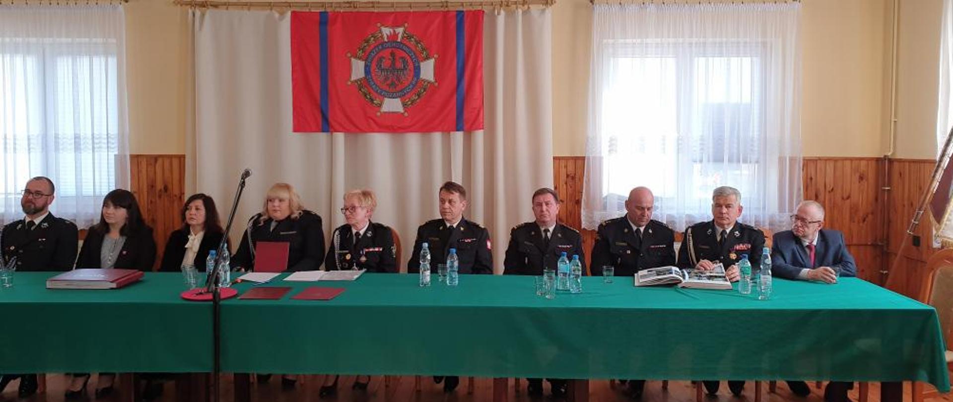 Zaproszeni goście:
- Mazowiecki Komendant Wojewódzki PSP nadbryg. Jarosław Nowosielski,
- Wójt Gminy Baranów Agata Trzop-Szczypiorska,
- Komendant Powiatowy PSP w Grodzisku Mazowieckim st. bryg. Krzysztof Tryniszewski,
- Przedstawiciele władz samorządowych,
i przedstawiciele OSP Kaski siedzą za stołem prezydialnym. 