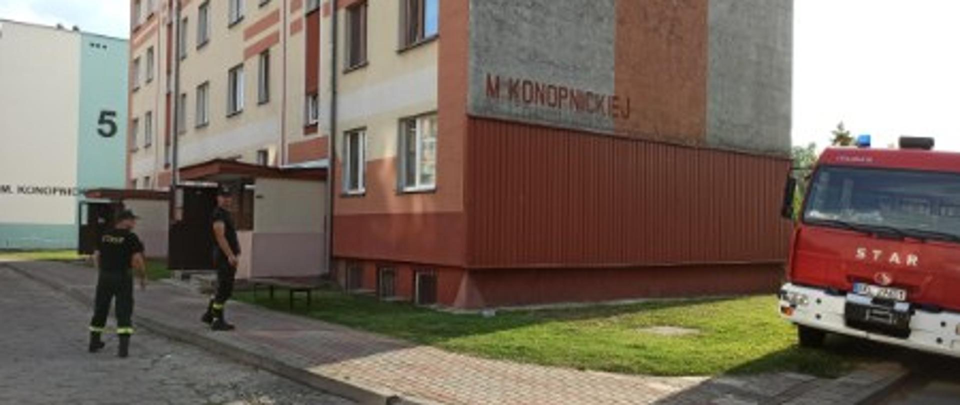 Na zdjęciu widać strażaków idących do bloku w celu informowania o ewakuacji