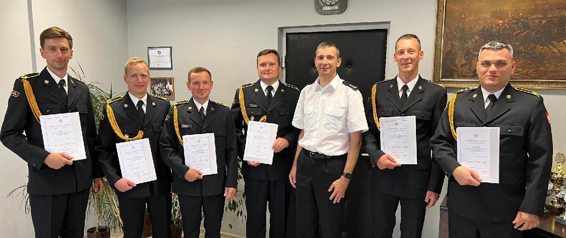 Sześciu absolwentów studium aspirantów wraz z wizytą u komendanta.