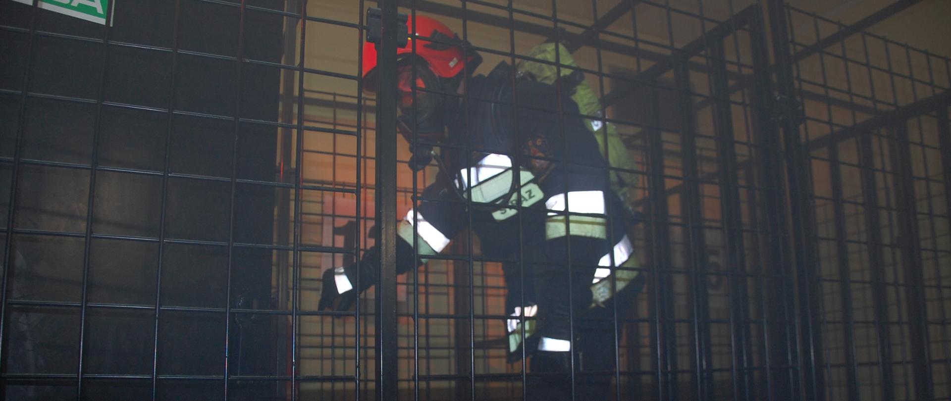 Strażak w ubraniu specjalnym z założoną na twarzy maską i aparatem powietrznym na plecach oraz w hełmie chroniącym jego głowę pokonuje przeszkody w komorze dymowej. Przeszkody wykonane są z metalowych elementów. Test odbywa się w całkowitym zaciemnieniu i zadymieniu.