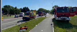 Na zdjęciu widoczne są trzy samochody ratowniczo - gaśnicze, dwie karetki pogotowia oraz motocykl policyjny.