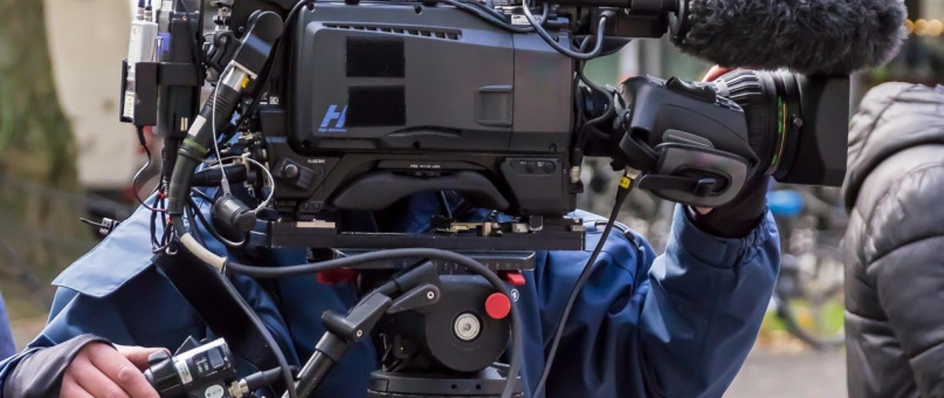 Operator stojący za kamerą telewizyjną