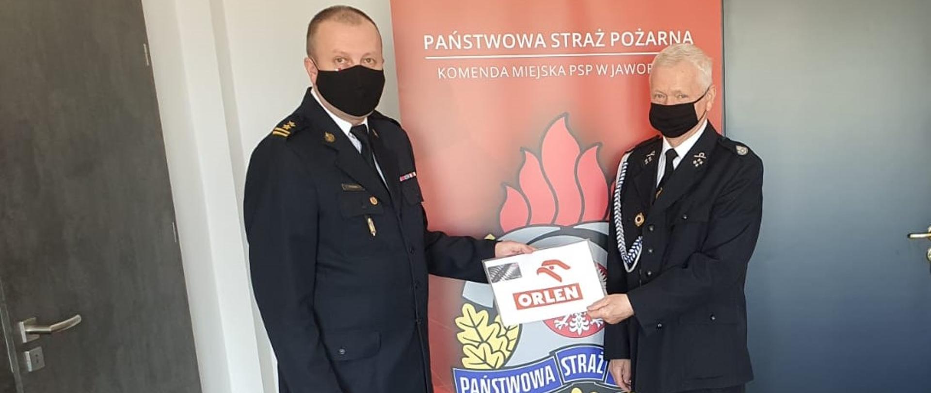 Zdjęcie przedstawia Komendanta Miejskiego PSP w Jaworznie wraz z Prezesem OSP Osiedle Stałe w czasie wręczania karty rabatowej w pomieszczeniu KM PSP Jaworzno.