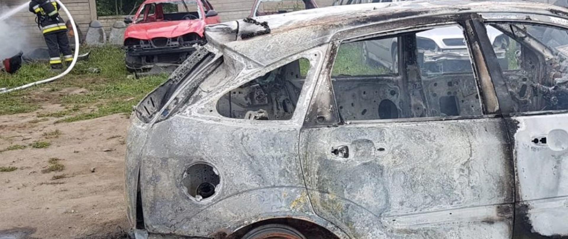 Zdjęcie przedstawia tył spalonego auta podczas akcji - pozostała sama karoseria