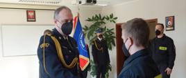 Na zdjęciu widzimy Komendanta Powiatowego składającego gratulacje jednemu z nowo przyjętych funkcjonariuszy.