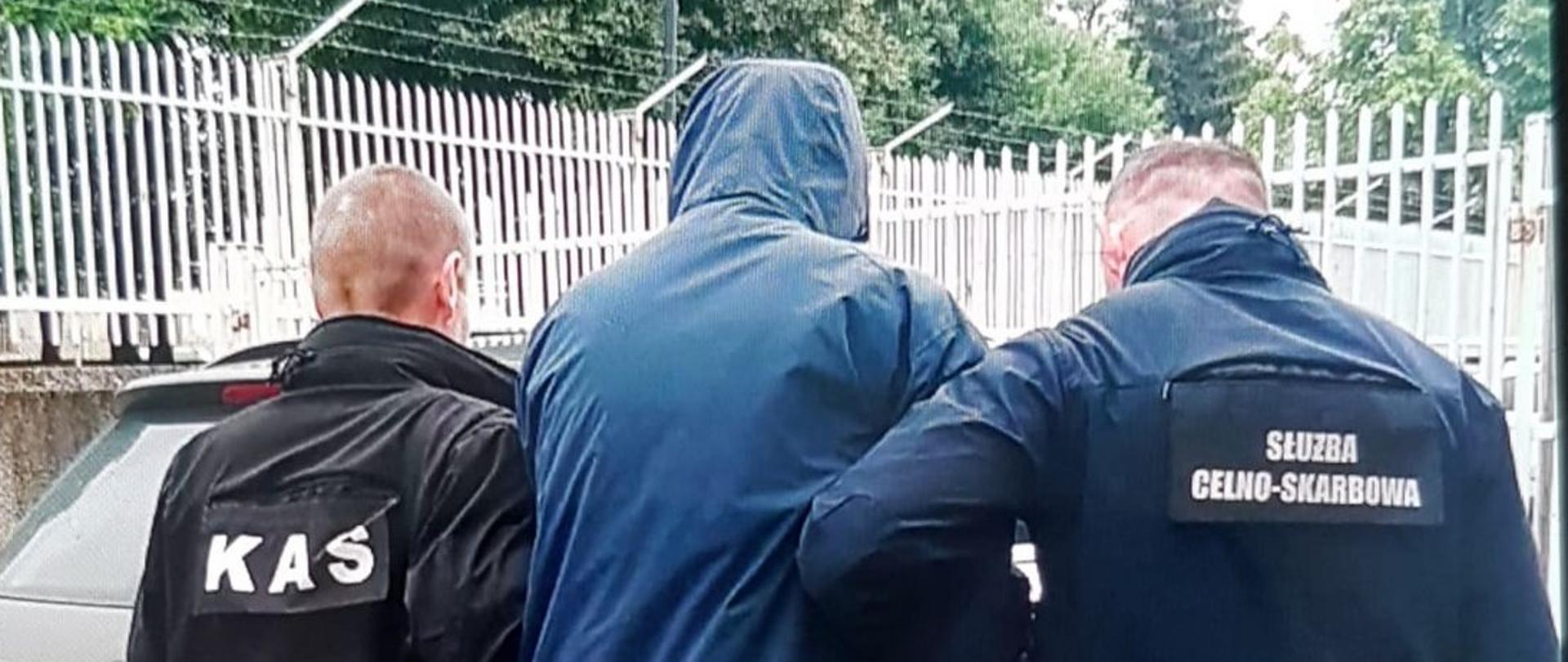 Funkcjonariusze prowadzą podejrzanego.