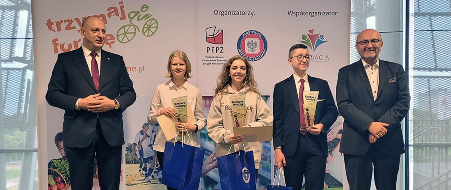 Laureaci konkursu stoją w rzędzie trzymając nagrody