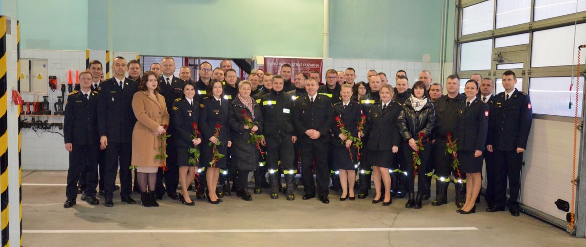 Zdjęcie pamiątkowe funkcjonariuszy i pracowników Komendy. Na pierwszym planie odchodzący strażak.