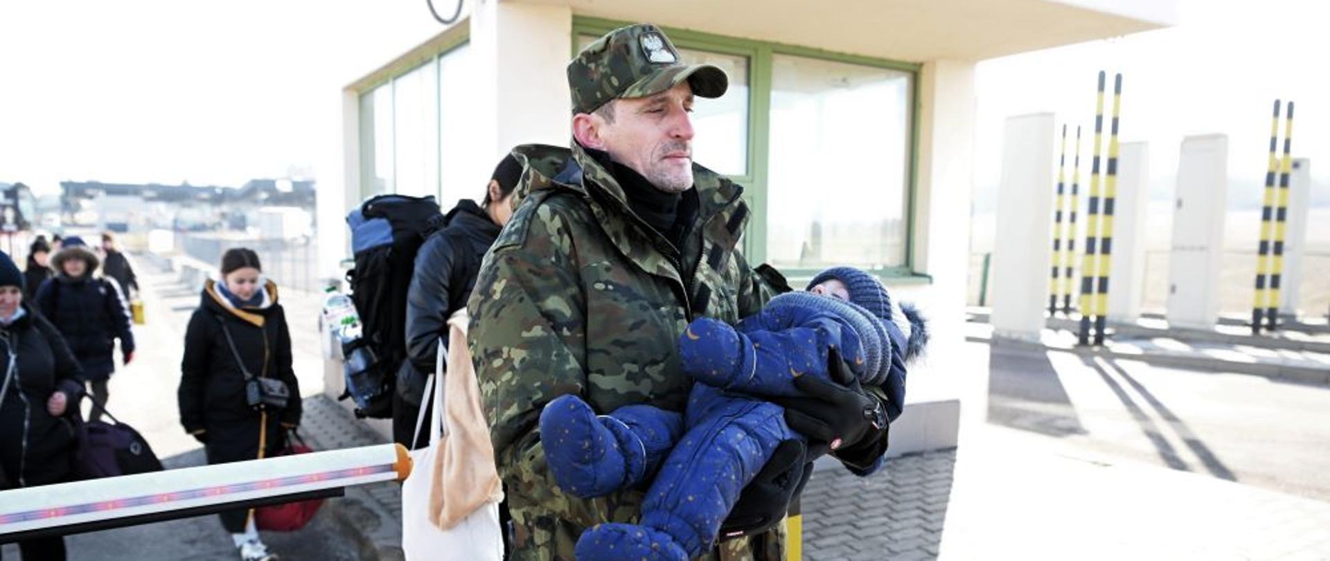 Un oficial de la Guardia Fronteriza ayuda a los refugiados de Ucrania a cruzar la frontera con Polonia en Medyka. Principalmente mujeres con niños buscan ayuda en Polonia.
Foto PAP / Darek Delmanowicz